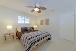 A bedroom with a bed, two bedside lamps, a ceiling fan, a window with blinds, and two wall-mounted picture frames. - 1 Mi to Dtwn Downey + Fenced Yard! (Downey)