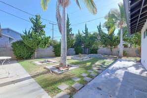 A backyard with a patio, a small garden area, and a variety of trees. - 1 Mi to Dtwn Downey + Fenced Yard! (Downey)