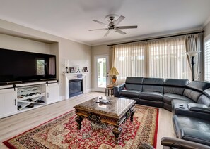 A living room with a fireplace, a sofa, a coffee table, and a television.