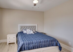 A bedroom with a bed, a nightstand, and a wall socket.