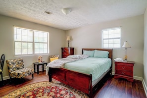 A bedroom with a bed, two nightstands, a chair, a dresser, and a patterned rug. - 7 Mi to Mall of Georgia: Fire Pit & Yard (Buford)