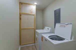 A laundry room with a wooden door, a washing machine, and a dryer.