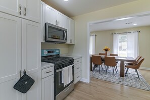 A modern kitchen with white cabinetry, a built-in microwave, and a gas stove. - 2 Mi to MSU Campus: Starkville 4BR Home (Starkville)