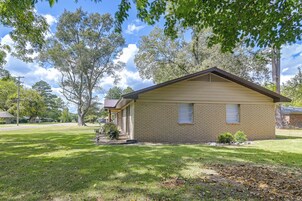 A single-story house with a brick exterior, a front porch, and a small front yard.