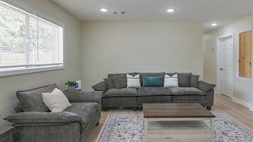 A living room with two grey sofas, a coffee table, and a patterned rug.