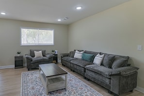 A living room with a sofa, a coffee table, a side table, and a window with blinds. - 2 Mi to MSU Campus: Starkville 4BR Home (Starkville)