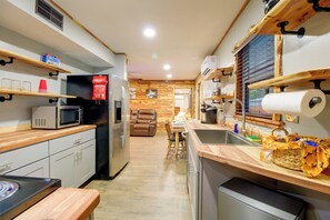 A compact kitchen with a refrigerator, microwave, and wooden cabinets. - 1/2 Mi to Marina! Modern Bull Shoals Lake Cabin (Bull Shoals)