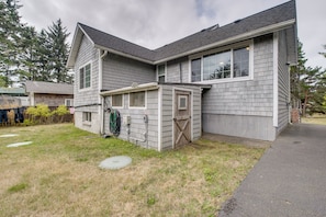 A two-story house with a garage, a covered porch, and a small front yard. - Half-mile to Beach! Coastal Washington Hideaway (Grayland)