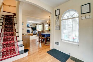 A staircase with a red carpet, a dining area with a table and chairs, and a window with blinds. - Half-mile to Beach! Coastal Washington Hideaway (Grayland)