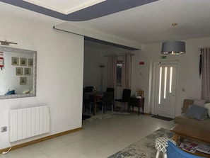 En stue med sofa, sofabord og et spisebord med stole.