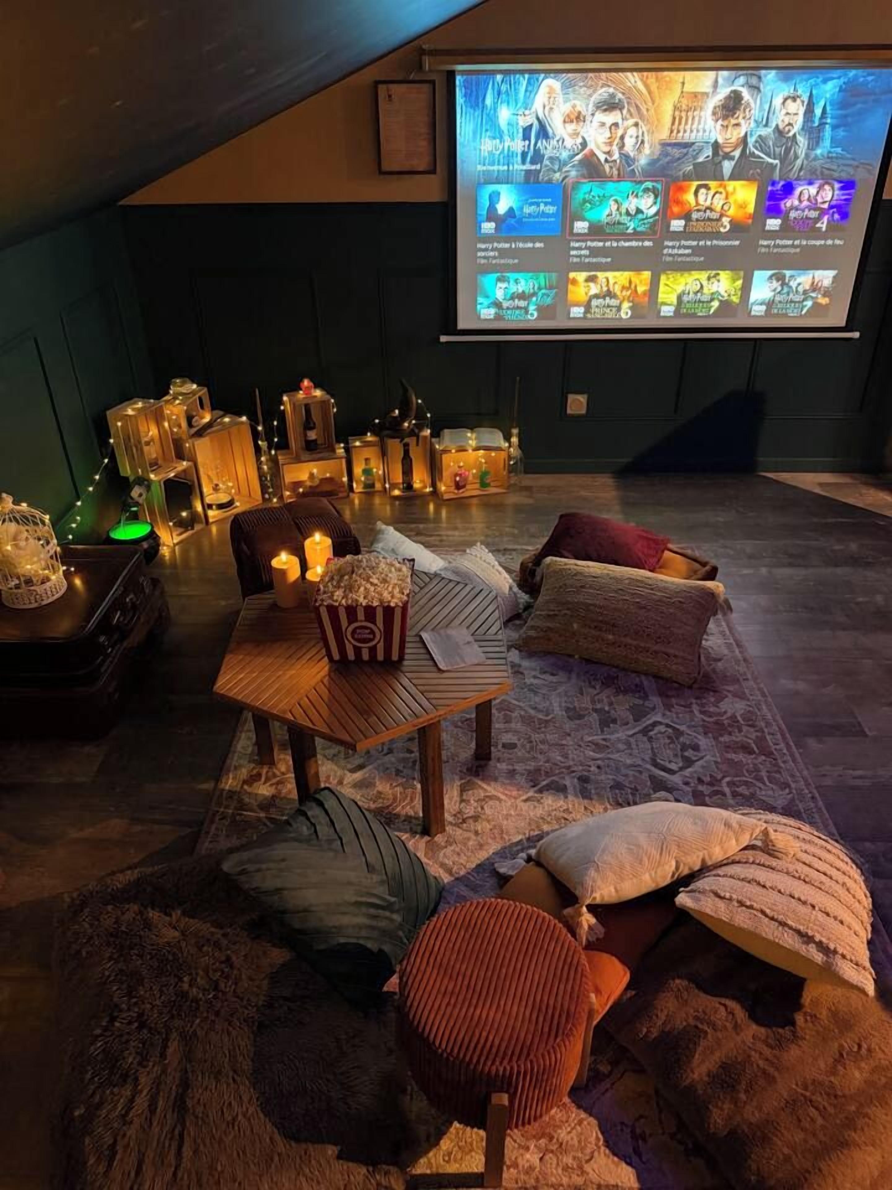 Un cinema acollidor amb una pantalla gran que mostra opcions de pel·lícules, seients confortables i il·luminació ambiental.
