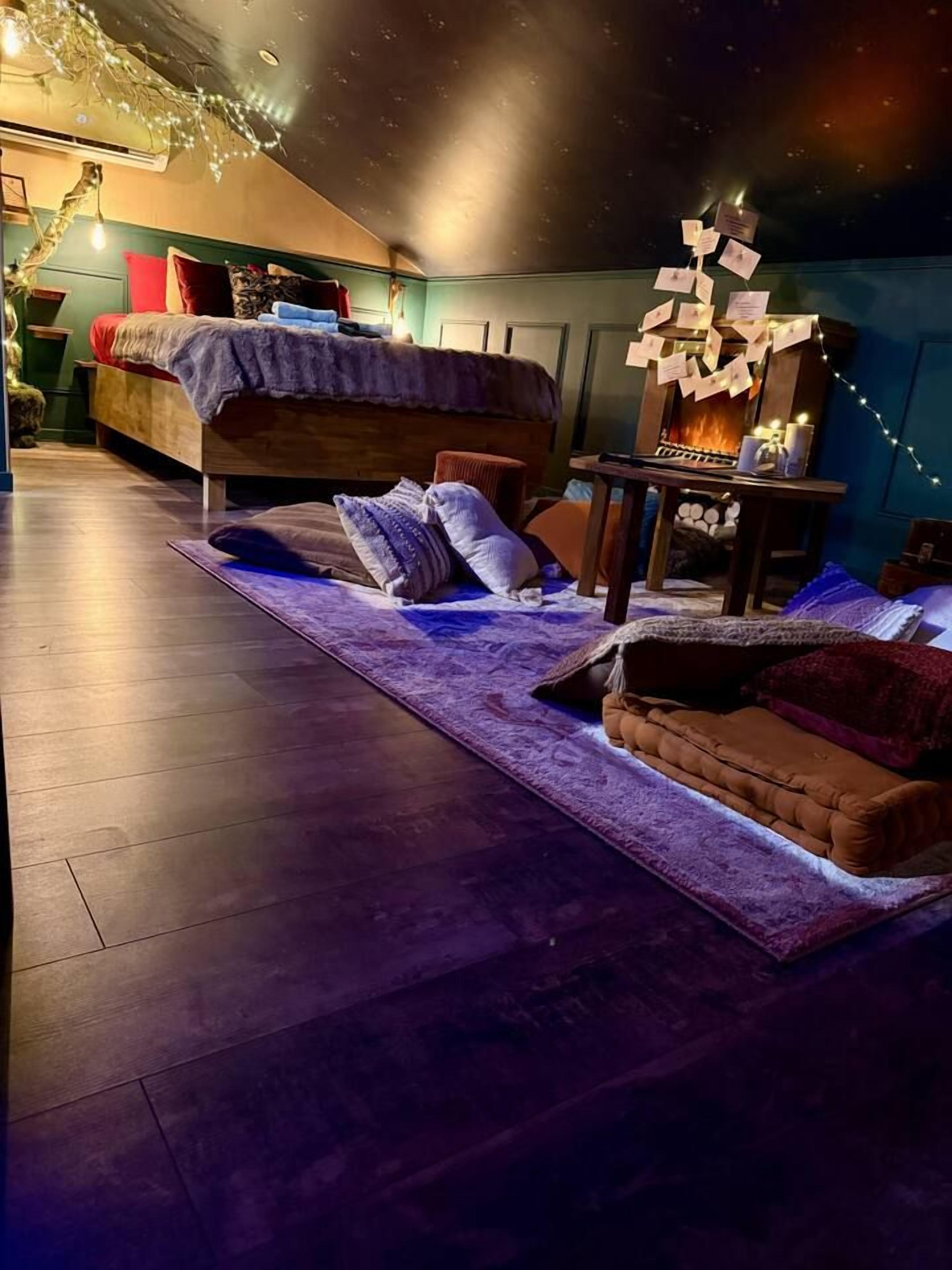 Ein gemütliches Schlafzimmer mit Bett, einem kleinen Tisch und einem Kamin.