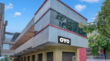 Un edificio con un evidente cartello 'OYO' sulla facciata, caratterizzato da uno stile architettonico moderno con tetto piatto e ampie finestre.