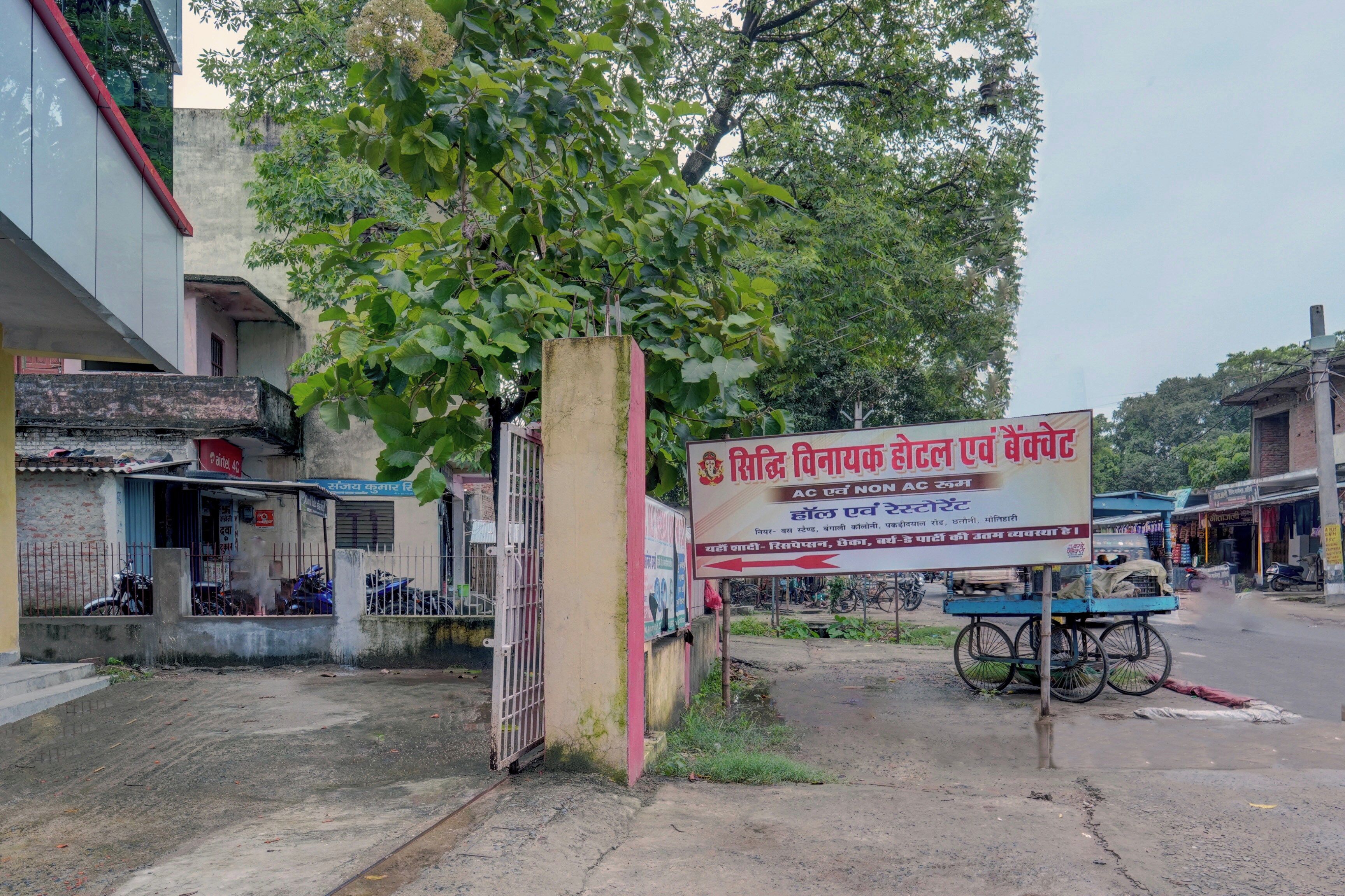 Une enseigne indiquant un hôtel, avec une entrée bien visible et un vélo garé devant.