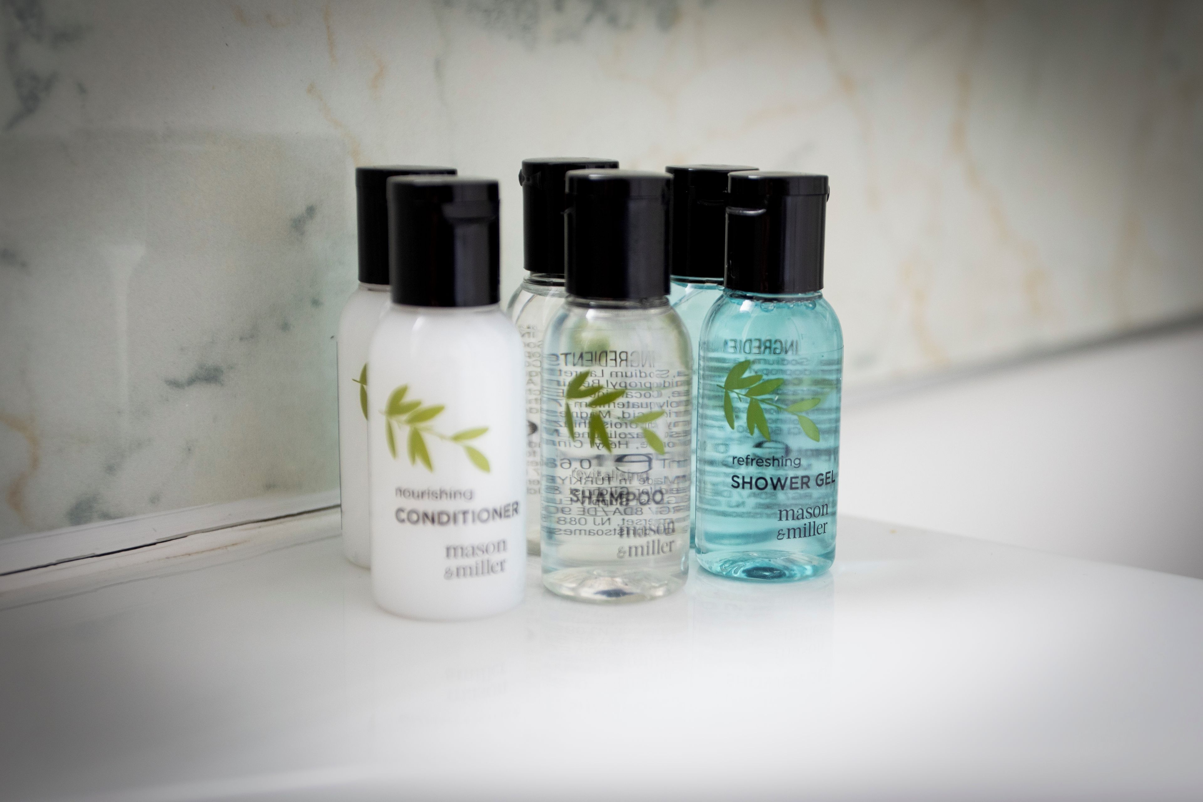 Three bottles of personal care products on a white surface.