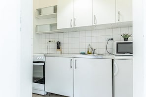 A kitchen with white cabinets, a microwave, and an oven. - Vienna Embassy Escape 2BR near Belvedere (Vienna)