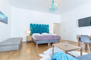 A modern bedroom with a bed, bedside tables, a desk, and a television. - Vienna Embassy Escape 2BR near Belvedere (Vienna)