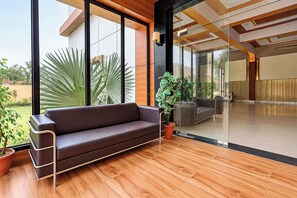 A modern interior with a sofa, potted plants, and a large glass wall.