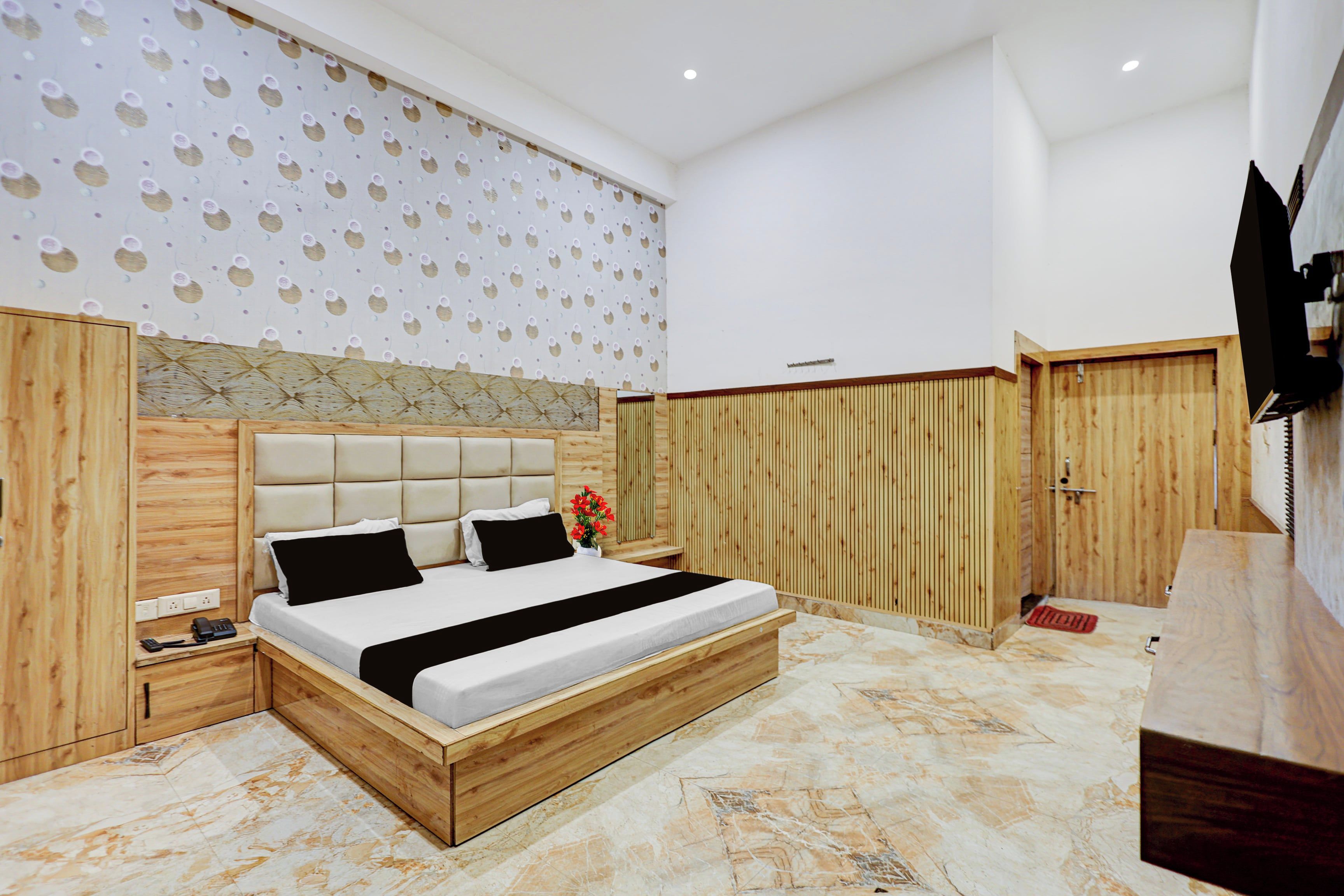 A modern bedroom with a large bed, wooden headboard, and a wall with a circular pattern.