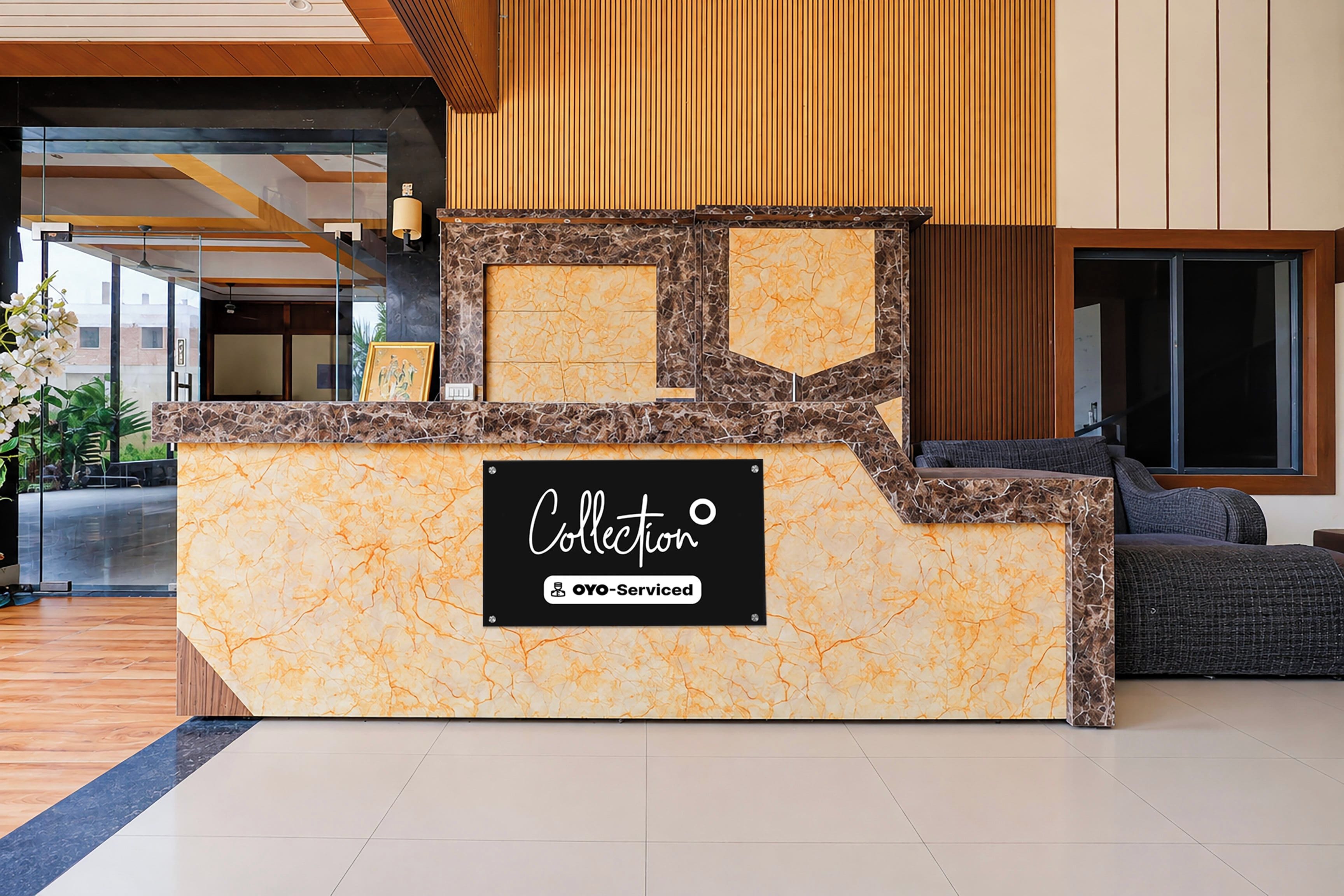 A reception desk with a marble top and a sign that reads 'Collection OYO-Serviced'.