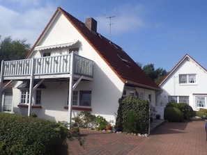 A two-story house with a balcony, a chimney, and a satellite dish. - Holiday Apartment With 1 Bedroom (Wyk auf Foehr)