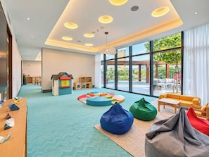 A children's play area with colorful seating and a view of the outdoors. - 3BR Address Opera High Floor Burj View (Dubai)