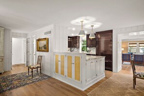 A spacious kitchen with white cabinetry, a central island, and pendant lighting. - GORGEOUS REHOBOTH HOME WITH PRIVATE POOL - 518 New Castle St (Rehoboth Beach)