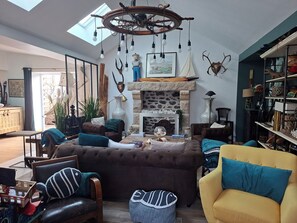 Ein gemütliches Wohnzimmer mit Kamin, bequemen Sitzgelegenheiten und einem Oberlicht.