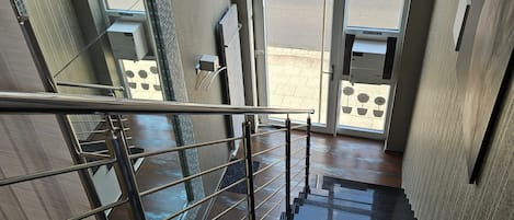 A staircase with a metal railing leading to an entrance with glass doors.