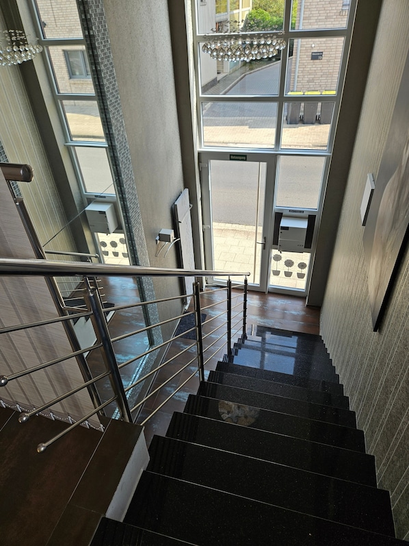 A staircase with a metal railing leading to an entrance with glass doors.