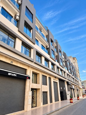 Ein mehrgeschossiges Gebäude mit modernem architektonischen Design, das große Fenster und eine glatte Fassade aufweist.