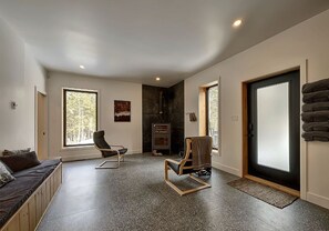 A modern living room with a fireplace, seating area, and large windows. - La Tanière de l'Ours BJÖRN HÎ, Refuge & Réconfort (Saint-Côme)