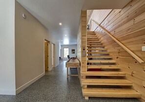 Ein Flur mit einer Holztreppe und einem Essbereich.