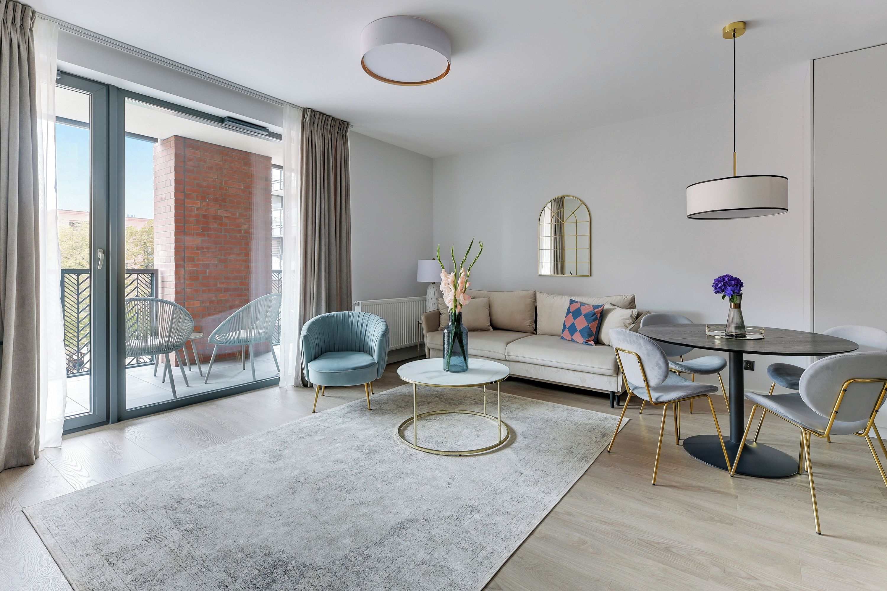 A modern living room with a sofa, chairs, a coffee table, and a dining area.