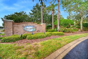 A brick wall with a sign for Bahama Bay Resort, surrounded by landscaped greenery and trees. - Disney Days 15 Min Away With Pools and Hot Tubs (Davenport)