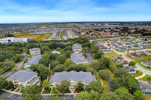 Een woongebied met meerdere twee verdiepingen tellende huizen, een zwembad en een groot gebouw op de achtergrond.