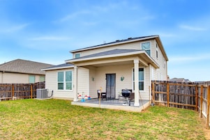 A single-story house with a covered porch, a patio, and a fenced backyard.