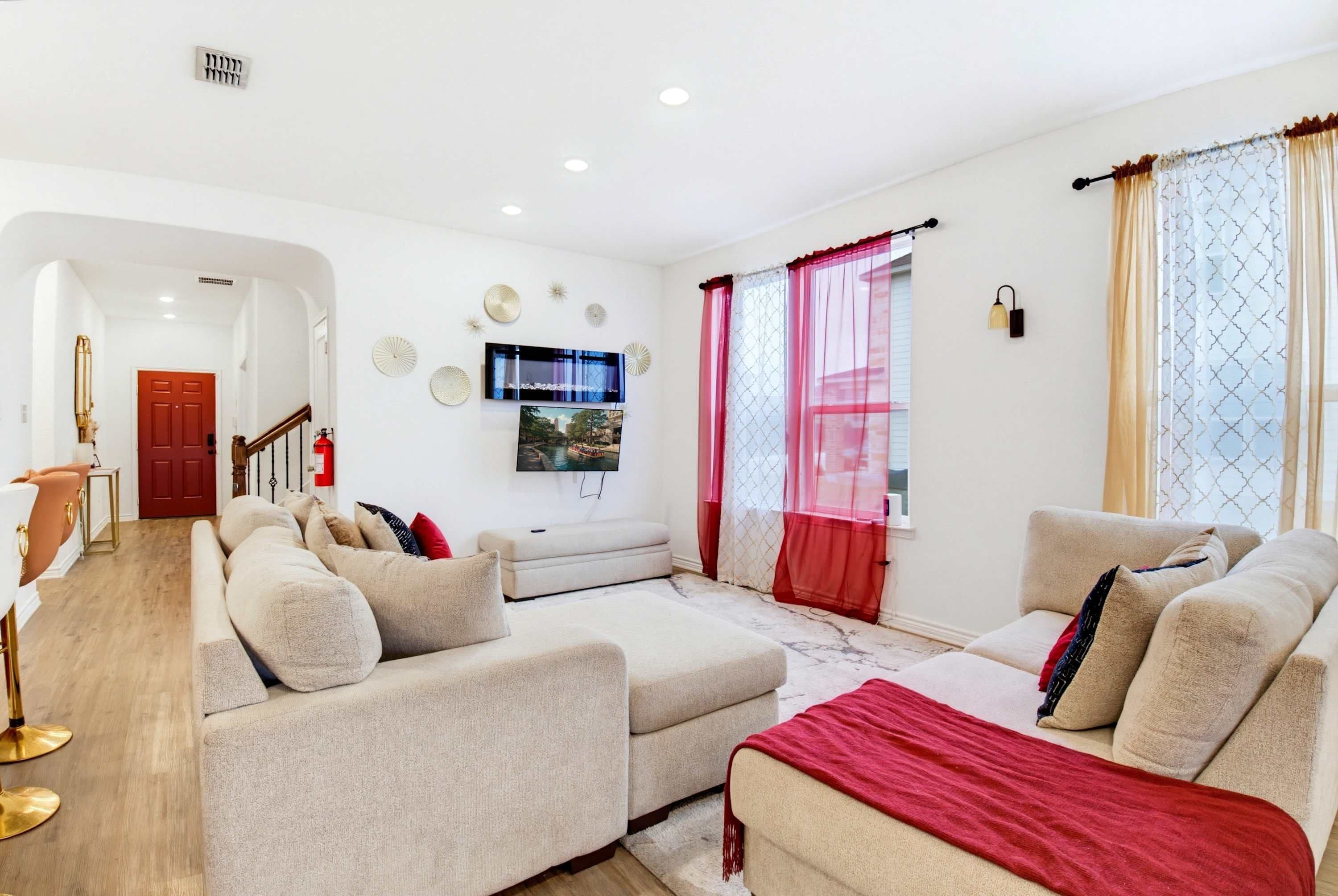 A modern living room with a sofa set, a flat-screen TV, and a fireplace.