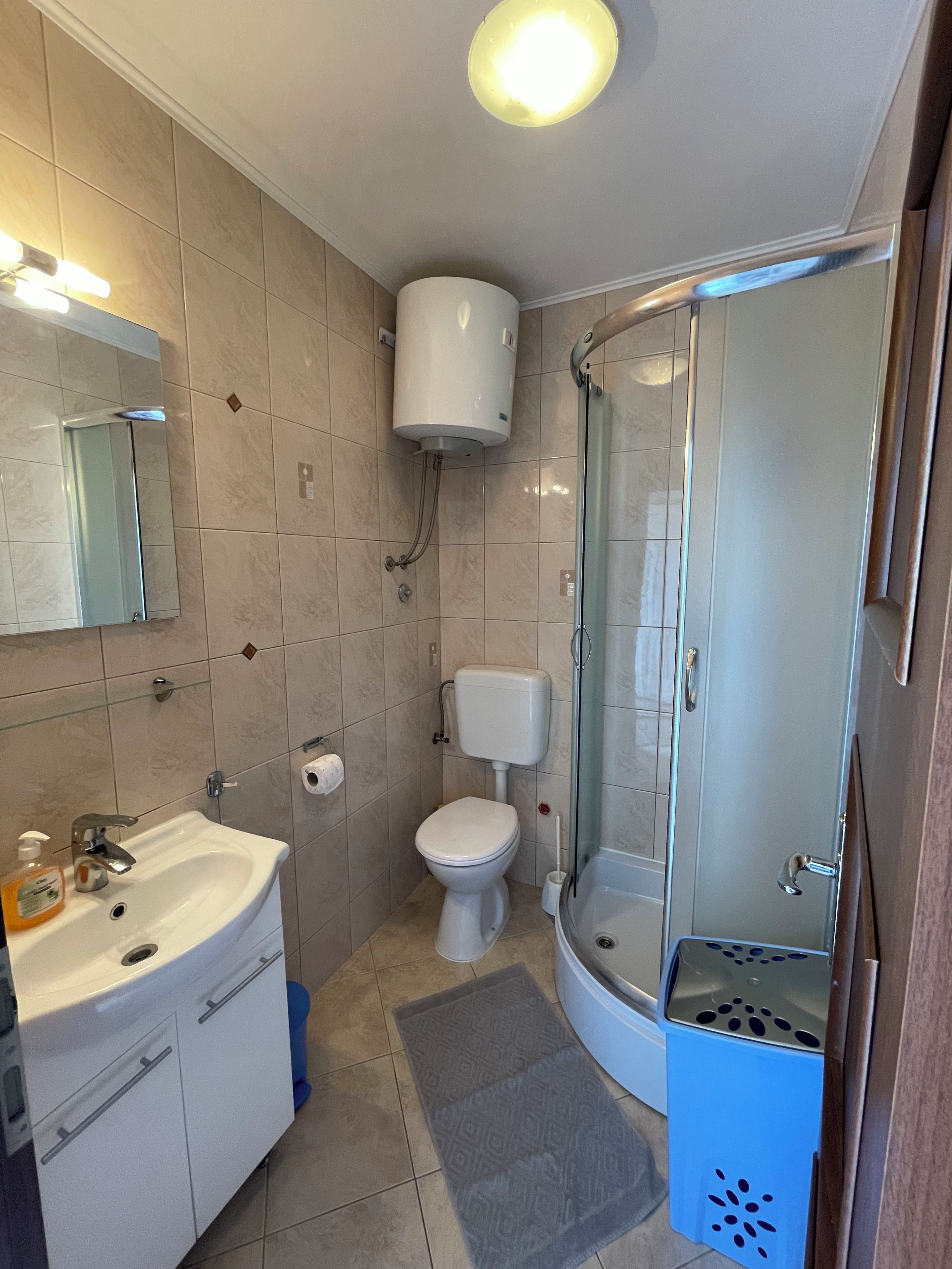 A bathroom with a sink, toilet, and glass shower enclosure.