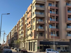 A multi-story hotel with balconies, a storefront, and a street view. - Dar Oud | Appartement 2 ch : Piscines, Jacuzzi, Gym & Parking - Marrakech (Marrakech)