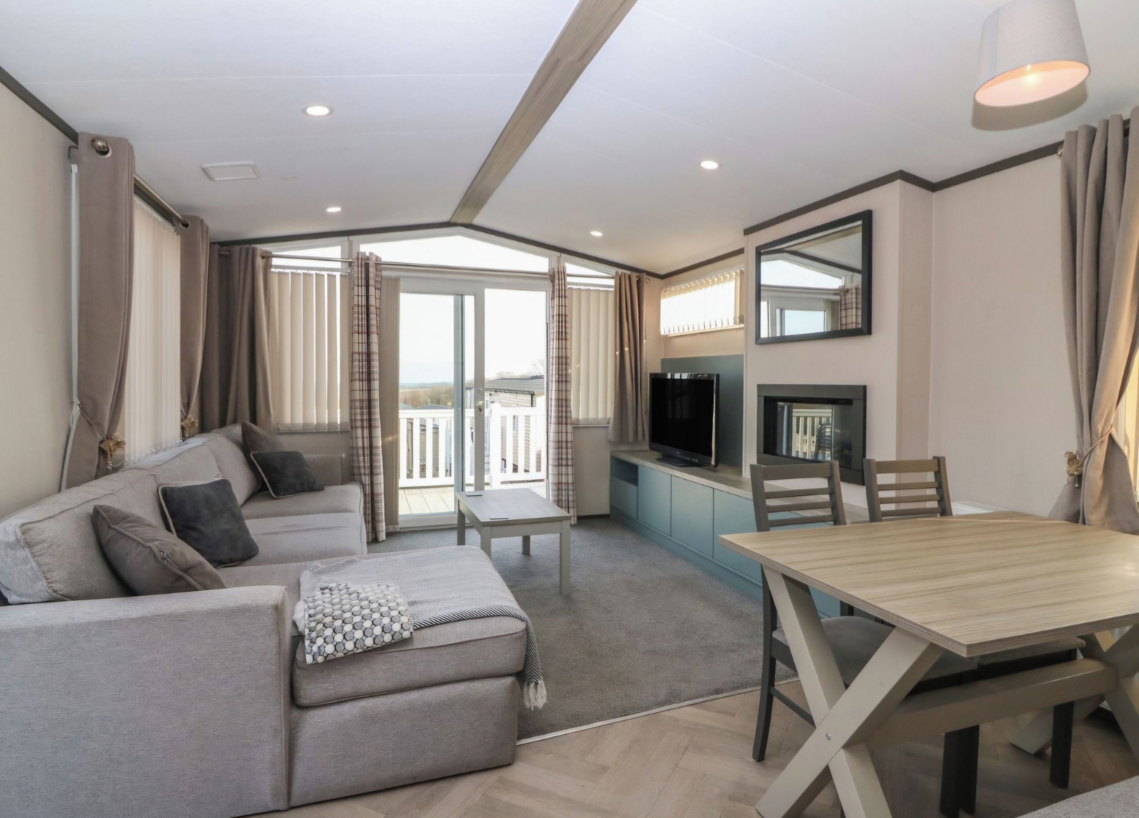 A modern living room with a sofa, a dining table, and a TV.