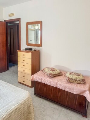 A bedroom with a wooden bed, a dresser, a mirror, and a door leading to another room. - Casa Vuolo-Imperato - a two-story house near Amalfi and Ravello (Pietre)