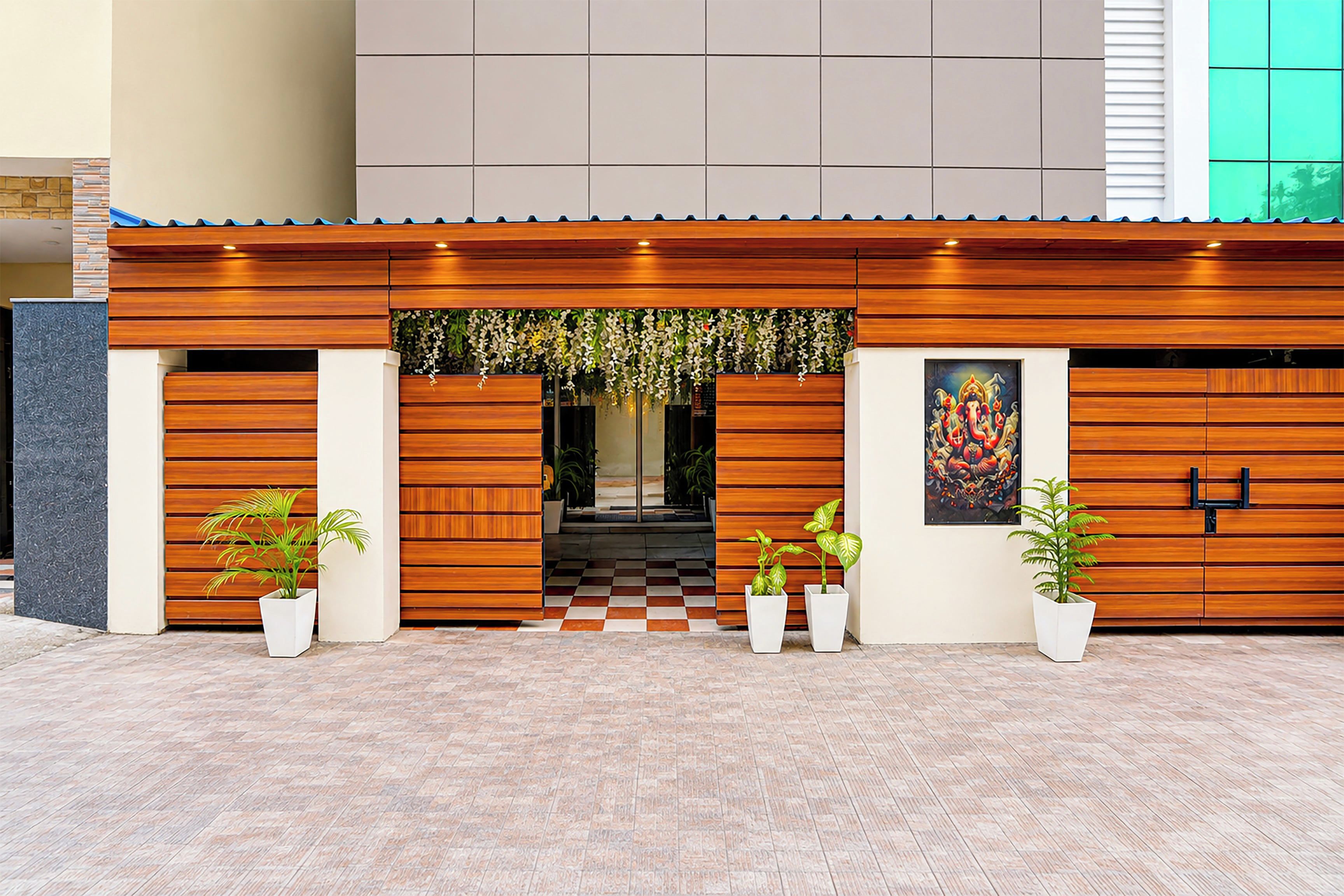 A modern building facade with a wooden panel design, a checkered entrance, and potted plants.