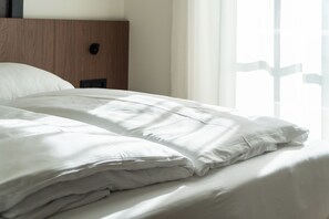 A neatly made bed with white linens in a hotel room. - Aparthotel Krone 1895 (Klausen)