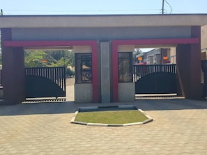 Una entrada con portón y un camino pavimentado que conduce a un edificio.