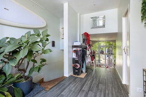 A hallway with a potted plant, a coat rack with bags, and a view to an outdoor area. - Bed and Breakfast 'Suite La Tête Dans Les Étoiles' with Shared Terrace and Wi-Fi (La Rochelle)