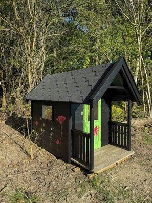 A small wooden structure with a sloped roof, a green door, and a wooden deck. - Newly built dream summer house on Sjællands Odde (Sjællands Odde)