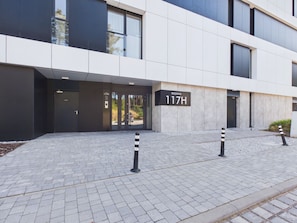 A modern building entrance with a sign indicating 'ROGOWO 117H'. - Hotel Shellter Resort & Spa (Rogowo)