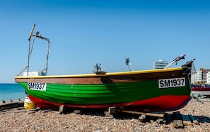 A boat with the registration number SM1937 on a pebbled beach. - Seaside Historic Townhouse, 1 Min to Beach, (Worthing)