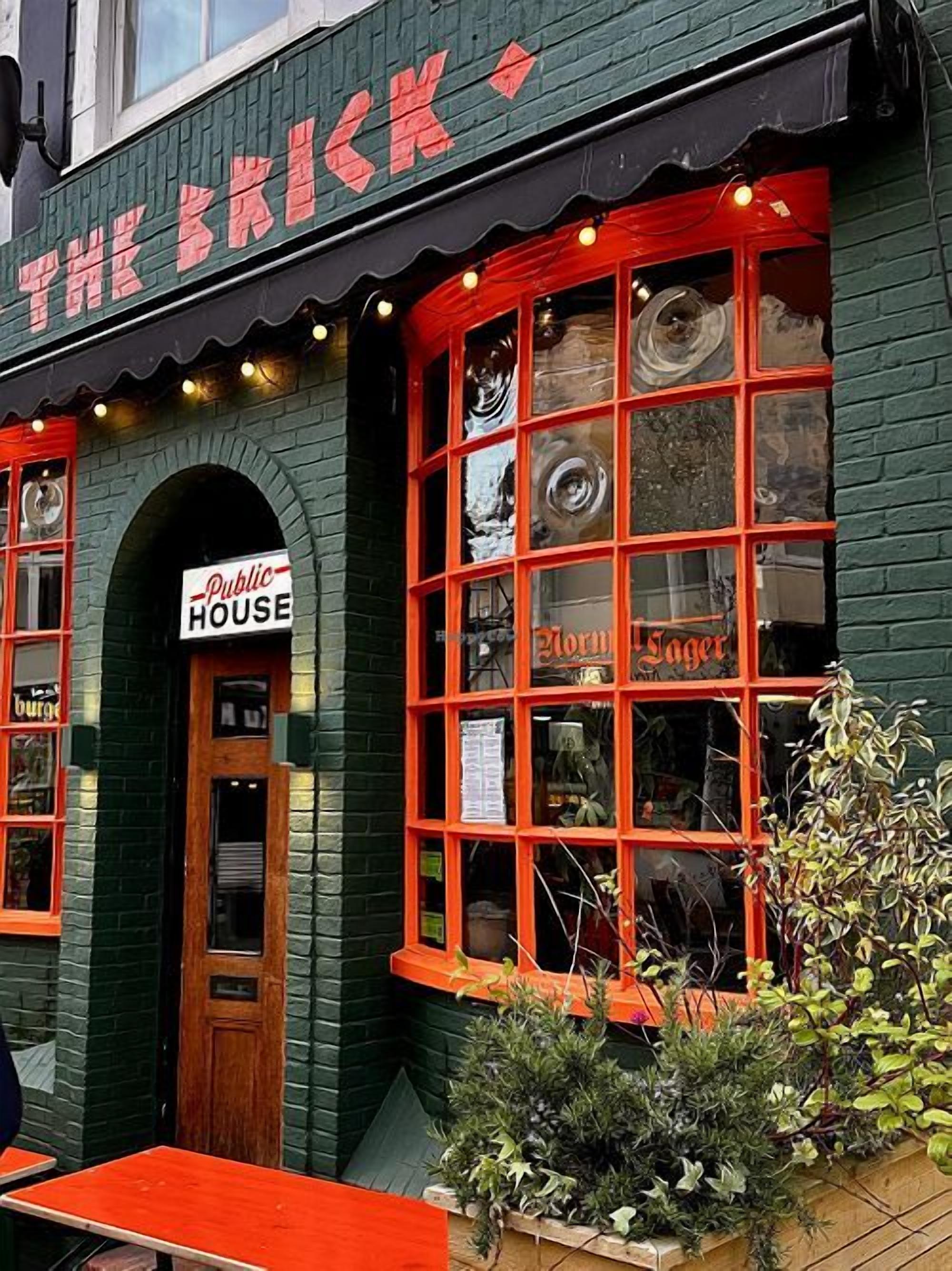 En murstensbygning med et skilt, der viser 'The Brick' og 'Public House'.